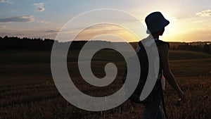 Wanderlust Adventure: Teen Boy Walking Across Summer Field at Sunset with Backpack, Steadicam Shot