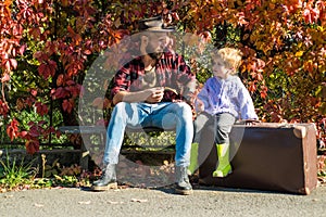 Wanderlust concept. Adventure with son. Telling stories about past times. Father with suitcase and his son. Bearded dad photo