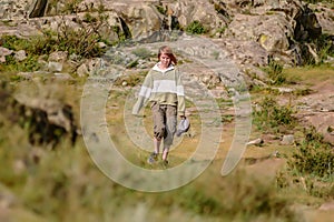 Wanderlust concept. Stylish hipster girl teens with cap in her hand walking in mountains.