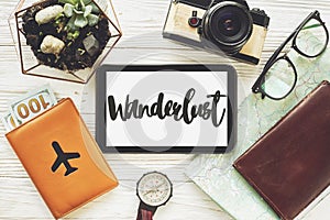 Wanderlust text sign on tablet with empty screen. travel concept