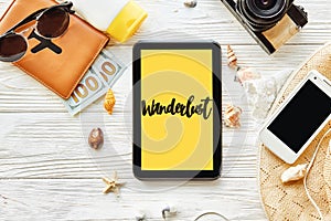 Wanderlust text sign. travel concept text on yellow tablet scre