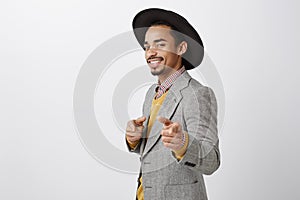 Wanna have some fun. Portrait of flirty confident african-american businessman in luxurious outfit and stylish hat