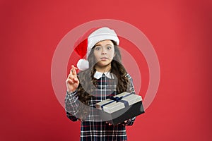 Want my wish. time for christmas holiday presents. small girl in santa hat. cheerful child red background. christmas kid