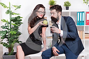 Want some. Sexy woman treat bearded man to apple. Business couple have snack break in office. Healthy natural snack for