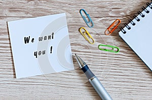 We Want You - card or notice on white workplace background with offise suplies
