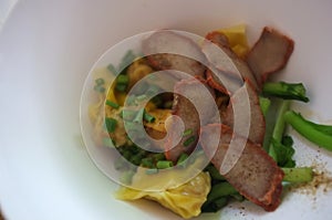 Wantan egg noodles and sliced roasted red pork . Asian street food photo