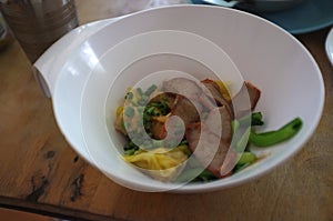 Wantan egg noodles and sliced roasted red pork . Asian street food photo