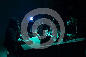 Wanted hackers coding virus ransomware using laptops and computers. Cyber attack, system breaking and malware concept.