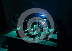 Wanted hackers coding virus ransomware using laptops and computers. Cyber attack, system breaking and malware concept.