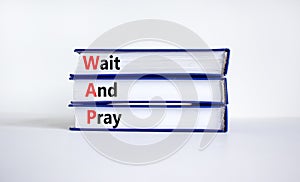 WAP, Wait and pray symbol. Books with concept words `WAP, Wait and pray`. Beautiful white background, copy space. Religion and W