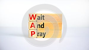 WAP, Wait and pray symbol. Wooden blocks with concept words `WAP, Wait and pray`. Beautiful white background, copy space. Religi