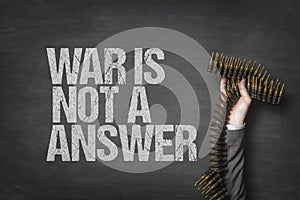 War is not a answer text on blackboard with businessman hand holding ammunition