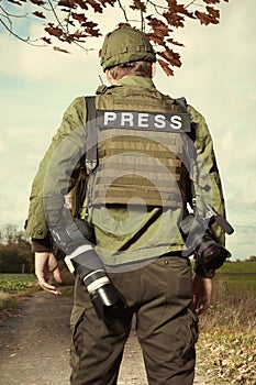 War photographer in conflict zone preparing for job photo