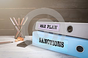 War Plan and Sanctions. Policy, law and influence concept. Two document binders on the office desk