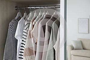 Wardrobe closet with different stylish clothes in room, closeup