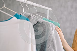 Wardrobe rack with stylish clothes near white wall indoors.