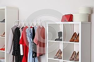 Wardrobe shelves with different stylish shoes and clothes indoors. Idea for interior