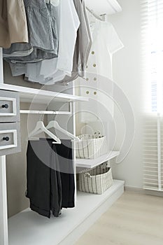 Wardrobe with shirts and pants hanging