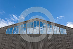 Warehouse building with blue sky reflected in windows, leading upwards