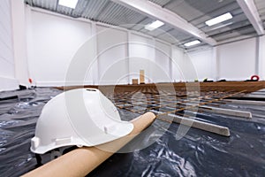 Warehouse construction site. White engineer helmet on floor