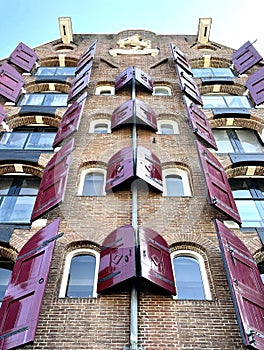 Warehouse D\'Eendracht (Unity) with red shutters at Singel 516-518 in Amsterdam, The Netherlands