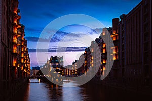 The Warehouse District - Speicherstadt in twilight. Tourism landmark of Hamburg. View of Wandrahmsfleet in light of photo