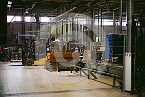 Warehouse employee in Overalls clothes, driver Reachtruck busy working on logistics Moving on loader pallets. human labor in manuf