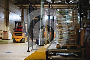 Warehouse employee in Overalls clothes, driver Reachtruck busy working on logistics Moving on loader pallets. human labor in manuf