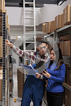 Warehouse employees managing inventory tracking with goods checklist