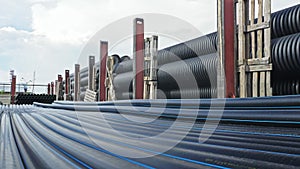 Warehouse of finished plastic pipes industrial outdoors storage site. Manufacture of plastic water pipes factory.