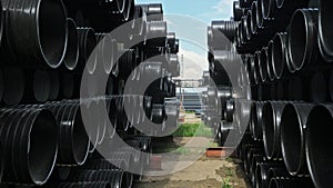 Warehouse of finished plastic pipes industrial outdoors storage site. Manufacture of plastic water pipes factory.