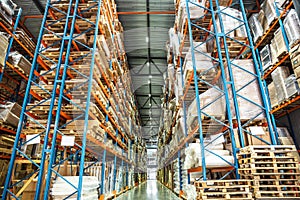 Warehouse or hangar storage racks or shelves with boxes and goods. Industrial logistic delivery and distribution