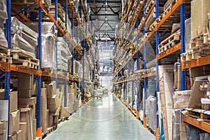 Warehouse or hangar storage racks or shelves with boxes and goods. Industrial logistic delivery and distribution