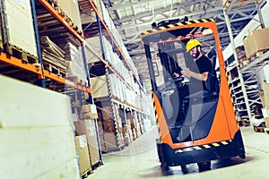Warehouse worker doing logistics work with forklift loader
