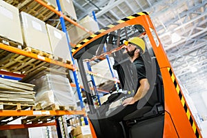 Warehouse worker doing logistics work with forklift loader