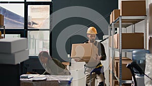 Warehouse intern seals cardboard boxes