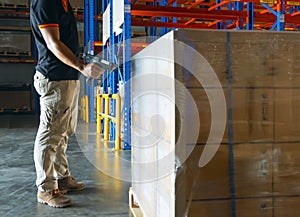 Warehouse inventory management, Cargo shipment, Interior of warehouse storage, Worker scanning barcode scanner with pallet goods