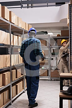 Warehouse loader carrying carton container in delivery service stockroom