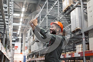 Warehouse manager checking his inventory in a large warehouse