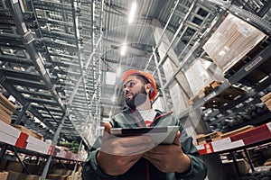 Warehouse manager checking his inventory in a large warehouse