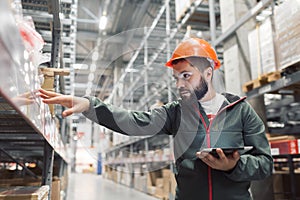 Warehouse manager checking his inventory in a large warehouse photo