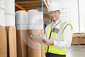 Warehouse manager checking his list on clipboard