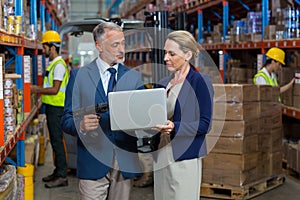 Warehouse manager and client using laptop