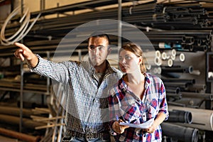 Warehouse manager indicates with his hand what to do to hired worker