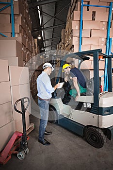 Warehouse manager talking with forklift driver photo