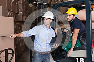 Warehouse manager talking with forklift driver photo