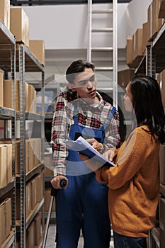 Warehouse manager teaching coworker managing order picking and fulfillment