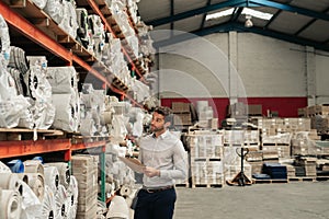 Warehouse manager using a clipboard while doing stock inventory