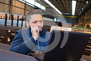 Warehouse manager using computer in warehouse