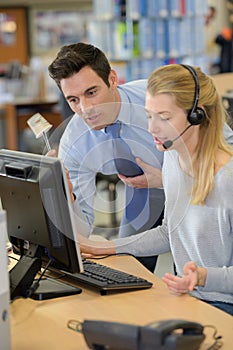 Warehouse manager and worker working together in warehouse office